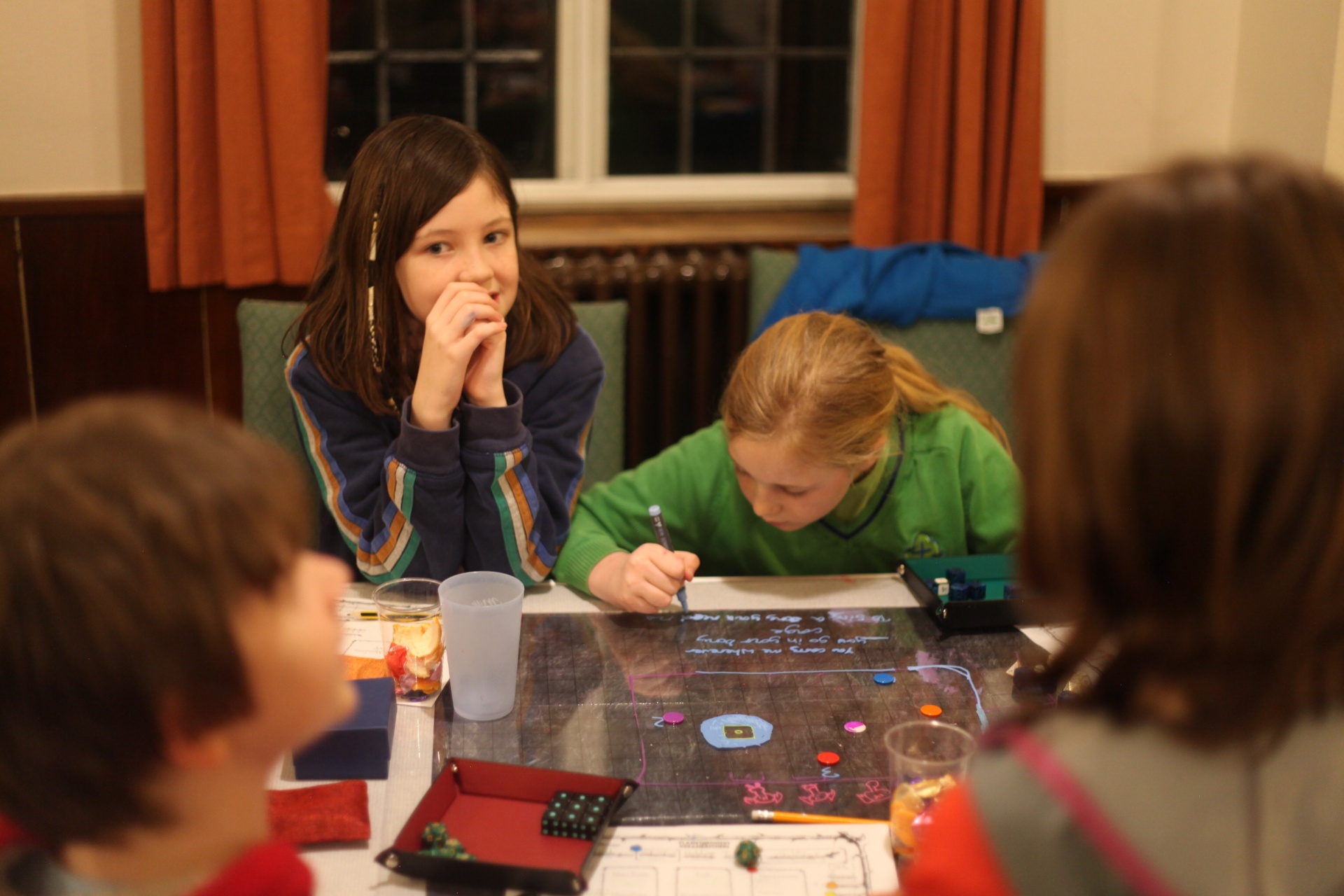 Children playing a tabletop adventure together with their Games Master